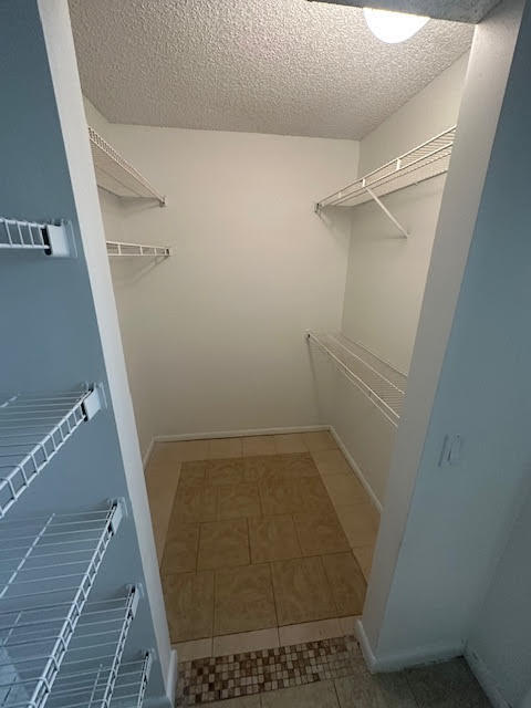 walk in closet with tile flooring