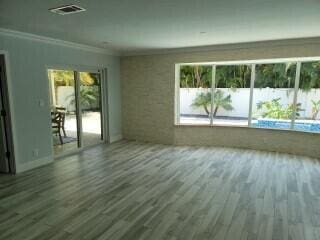 spare room featuring dark wood-type flooring and crown molding