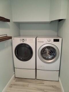 washroom featuring light hardwood / wood-style floors and washer and dryer