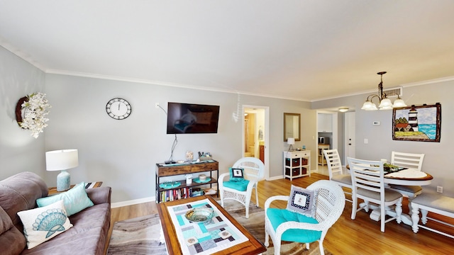 living room featuring a notable chandelier, ornamental molding, and hardwood / wood-style flooring