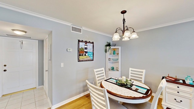 tiled dining space with a notable chandelier and crown molding