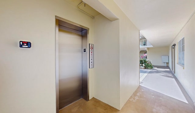 hall with concrete floors and elevator