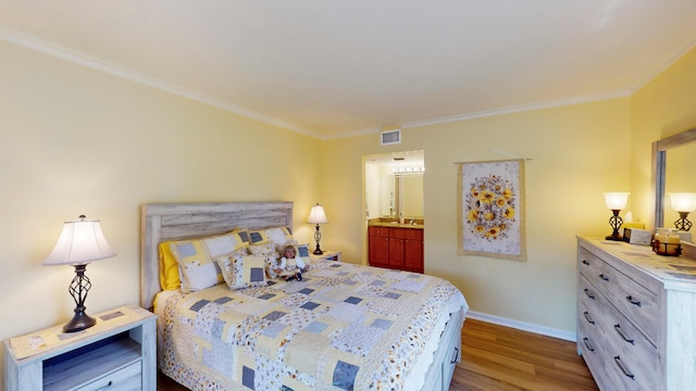 bedroom with crown molding, wood-type flooring, and connected bathroom