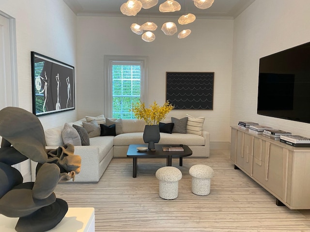 living room featuring a notable chandelier, crown molding, and light hardwood / wood-style flooring