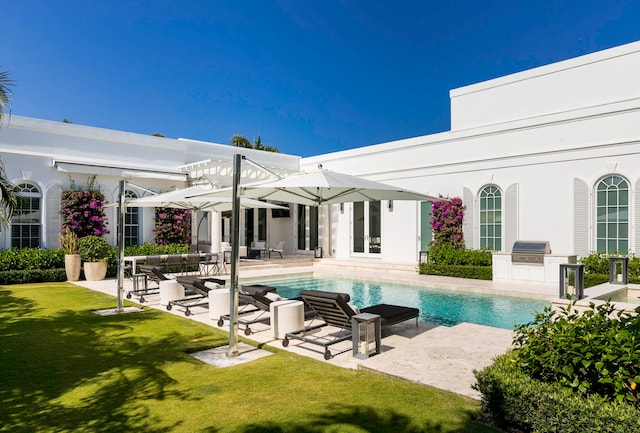 view of swimming pool with a pergola, exterior kitchen, a patio area, area for grilling, and a lawn