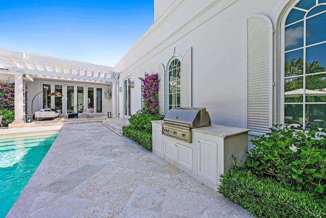 view of patio / terrace featuring a pergola, a grill, and an outdoor kitchen