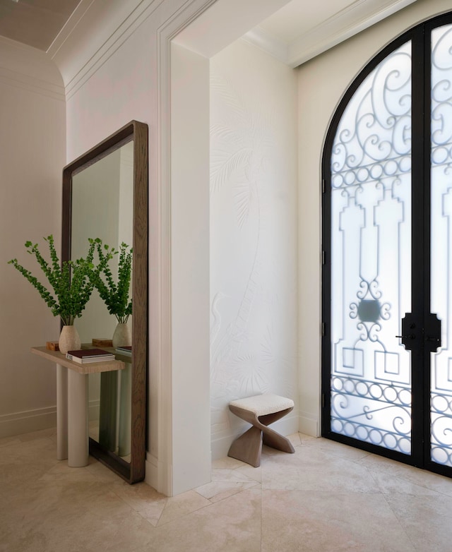 entryway with ornamental molding, french doors, and light tile floors