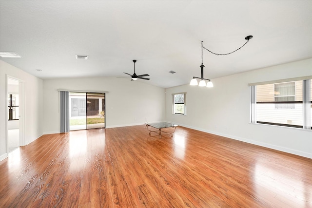 unfurnished room featuring plenty of natural light, ceiling fan, vaulted ceiling, and hardwood / wood-style floors