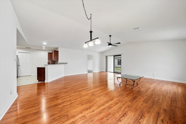 unfurnished living room featuring ceiling fan, light hardwood / wood-style flooring, and vaulted ceiling