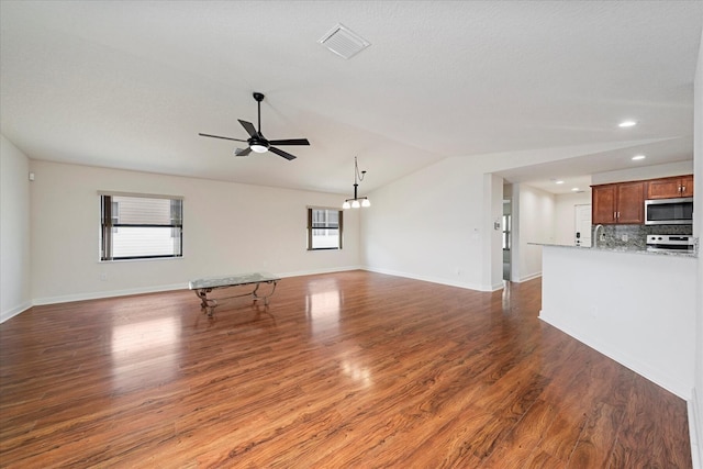 unfurnished living room with ceiling fan, lofted ceiling, sink, and wood-type flooring