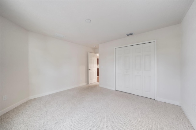 unfurnished bedroom featuring carpet flooring and a closet