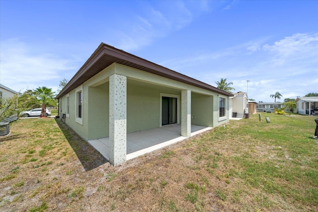 back of house with a yard and a patio area