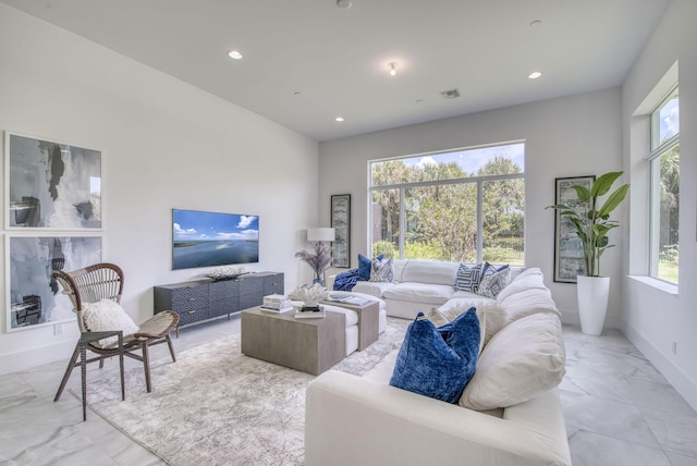 living area with marble finish floor, recessed lighting, visible vents, and baseboards