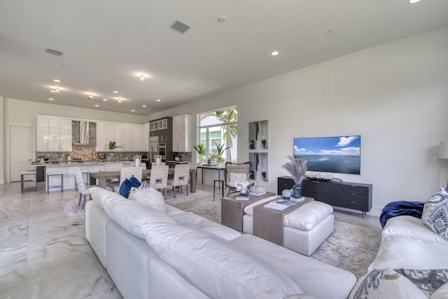 living area with marble finish floor, visible vents, and recessed lighting