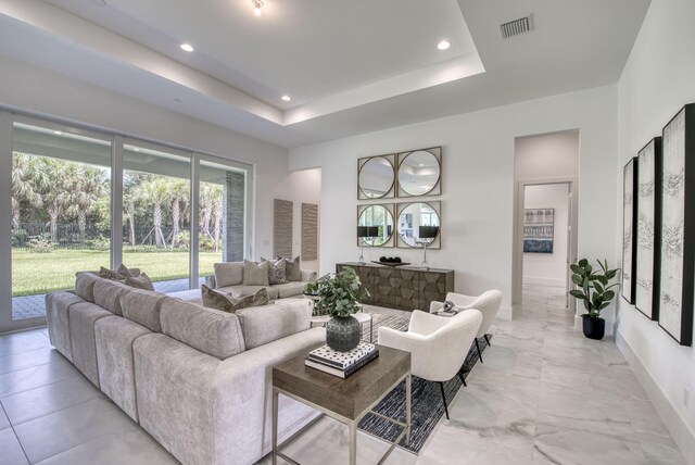 tiled living room with a tray ceiling