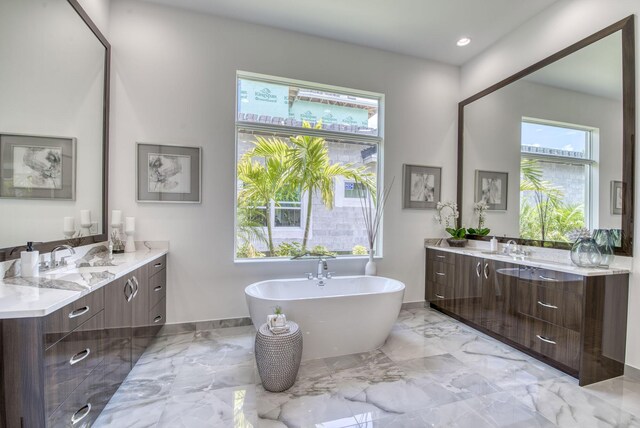 bathroom with tile patterned floors, vanity, and a bath