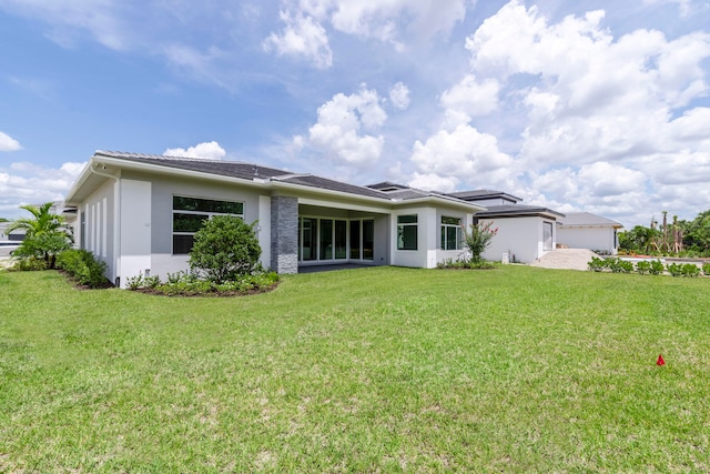 back of house featuring a lawn and a garage