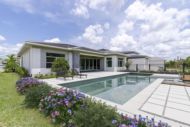 back of property featuring a fenced in pool, a patio, stucco siding, a lawn, and fence