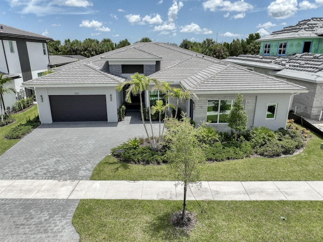 view of front of home featuring a front lawn, decorative driveway, and an attached garage