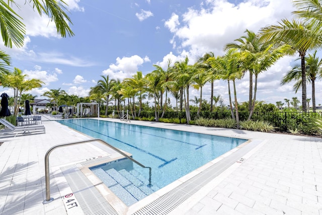 community pool with fence and a patio