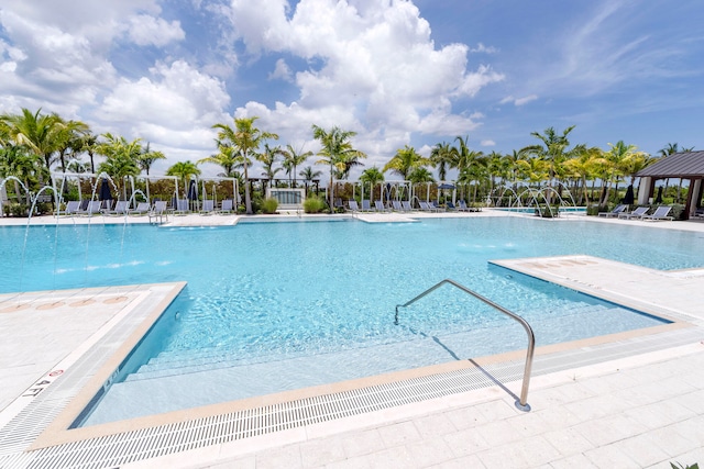 view of pool featuring pool water feature and a patio