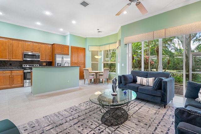 tiled living room featuring ornamental molding and ceiling fan