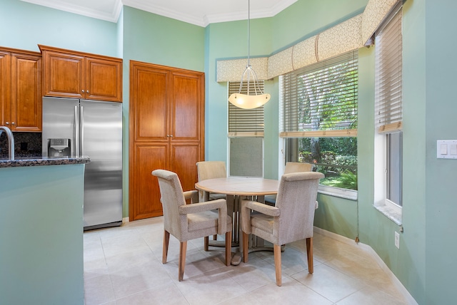 kitchen featuring light tile floors, sink, stainless steel dishwasher, hanging light fixtures, and an island with sink