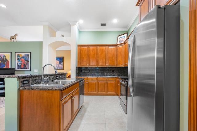 kitchen featuring light tile patterned flooring, appliances with stainless steel finishes, sink, backsplash, and dark stone counters