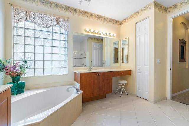 bathroom with vanity, tile patterned flooring, plenty of natural light, and plus walk in shower