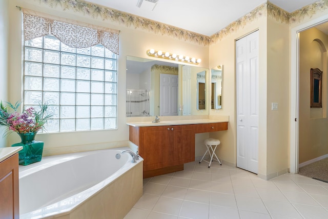 bathroom featuring a bathing tub, vanity, and tile flooring