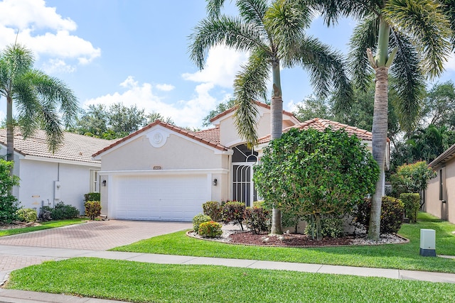 mediterranean / spanish-style home featuring a garage and a front yard