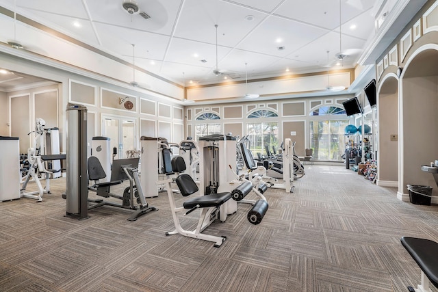 gym with crown molding, carpet floors, and a high ceiling