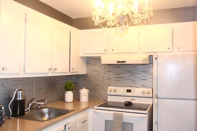 kitchen featuring backsplash, white appliances, exhaust hood, white cabinets, and a chandelier