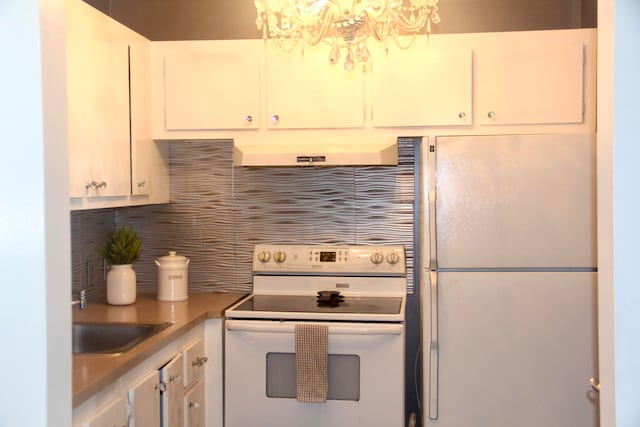 kitchen featuring tasteful backsplash, white appliances, sink, exhaust hood, and white cabinetry