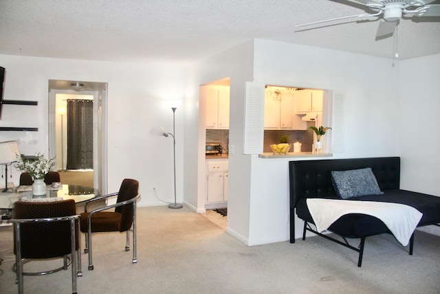 dining space featuring a textured ceiling and light colored carpet