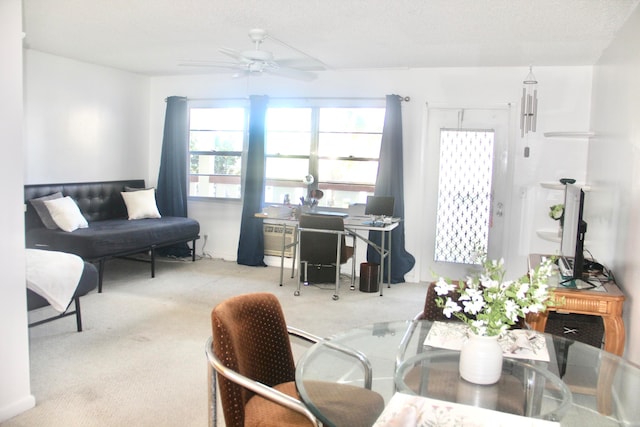 living room with ceiling fan, light colored carpet, and a textured ceiling