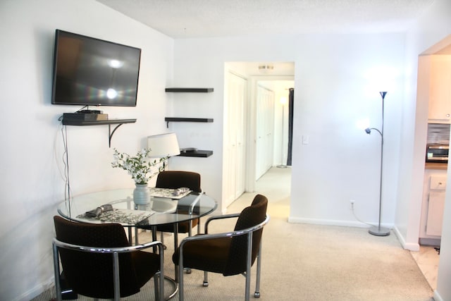 dining space featuring light carpet