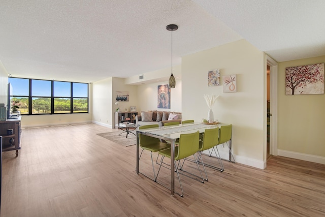 dining room featuring a textured ceiling and light hardwood / wood-style flooring