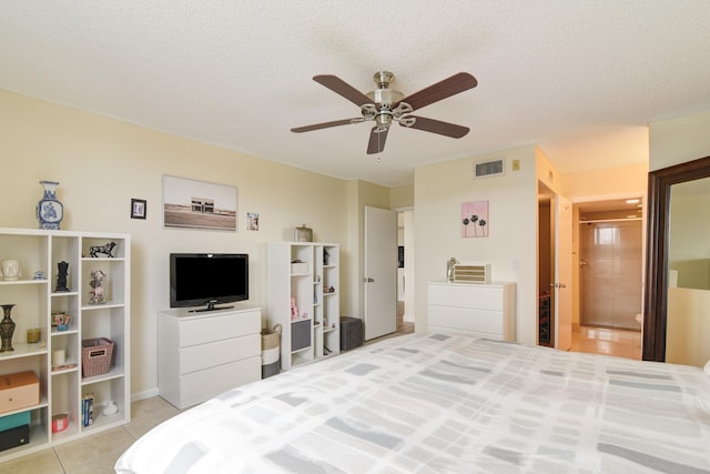 bedroom featuring a textured ceiling, ceiling fan, and light tile patterned flooring