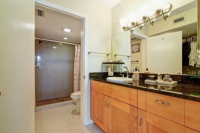 bathroom featuring tile patterned floors, curtained shower, vanity, and toilet