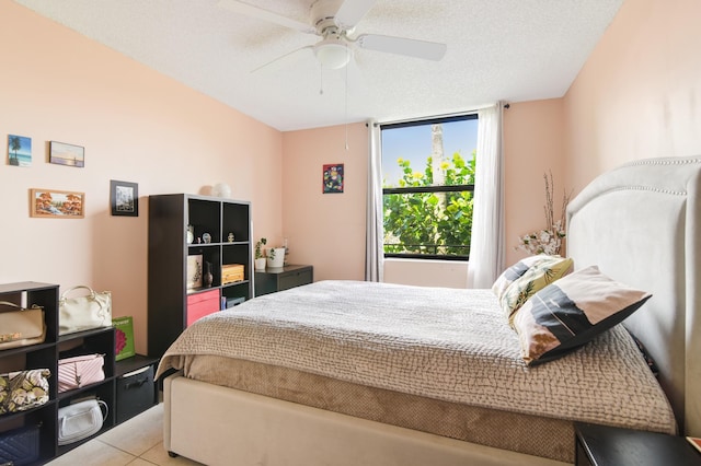 bedroom featuring light tile patterned floors, a textured ceiling, and ceiling fan