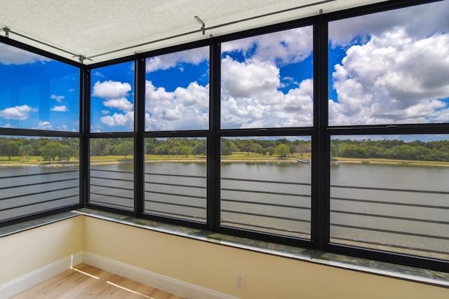 unfurnished sunroom with a water view