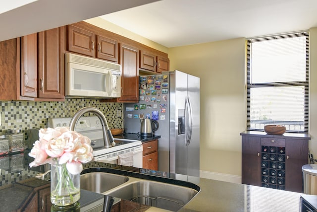 kitchen featuring decorative backsplash, stainless steel fridge, and stove