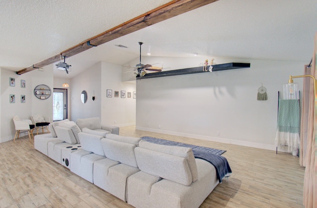 home theater with a textured ceiling, light wood-type flooring, lofted ceiling with beams, and ceiling fan