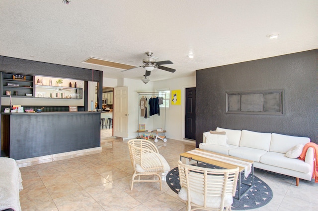 living room featuring a textured ceiling and ceiling fan