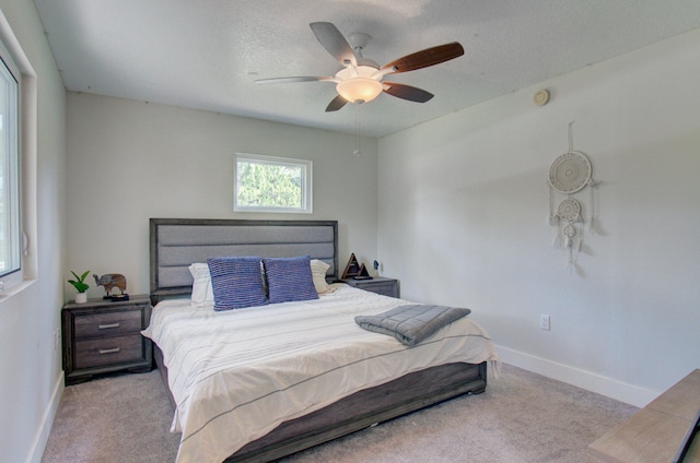 carpeted bedroom featuring a textured ceiling and ceiling fan