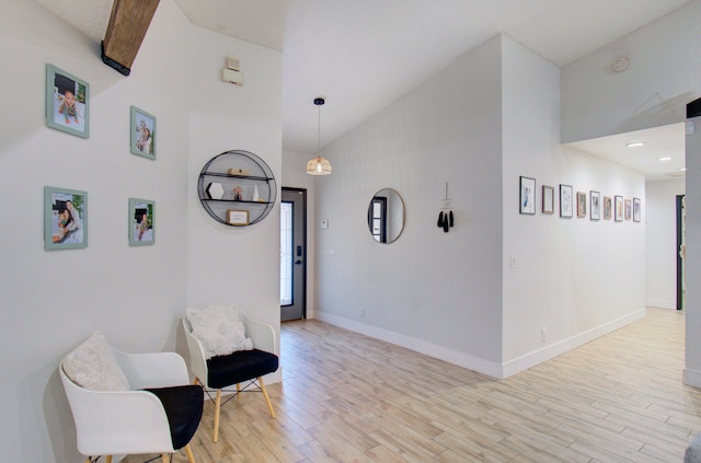 sitting room featuring a high ceiling and light hardwood / wood-style flooring