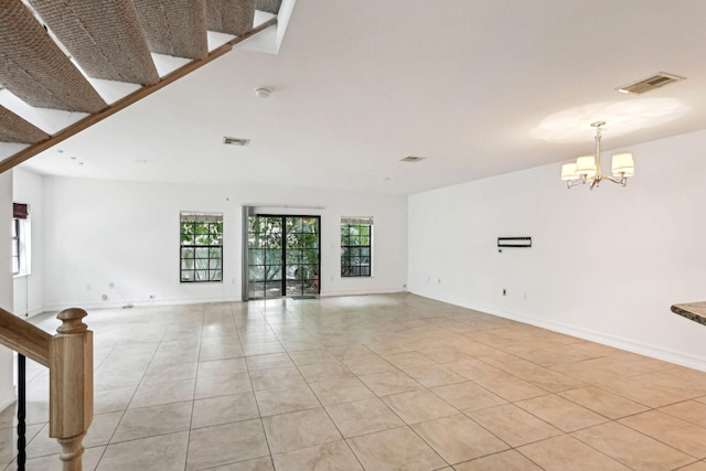 unfurnished living room featuring a chandelier and light tile patterned floors