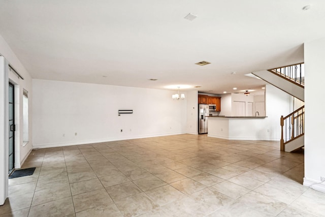 unfurnished living room with light tile patterned flooring and a chandelier