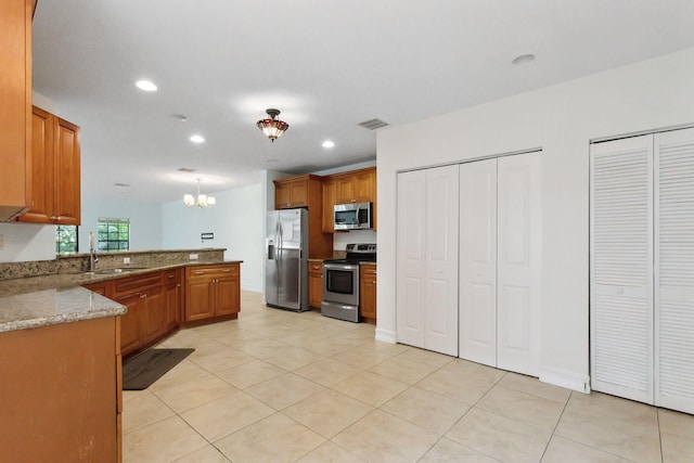 kitchen featuring pendant lighting, light stone countertops, light tile patterned floors, stainless steel appliances, and sink